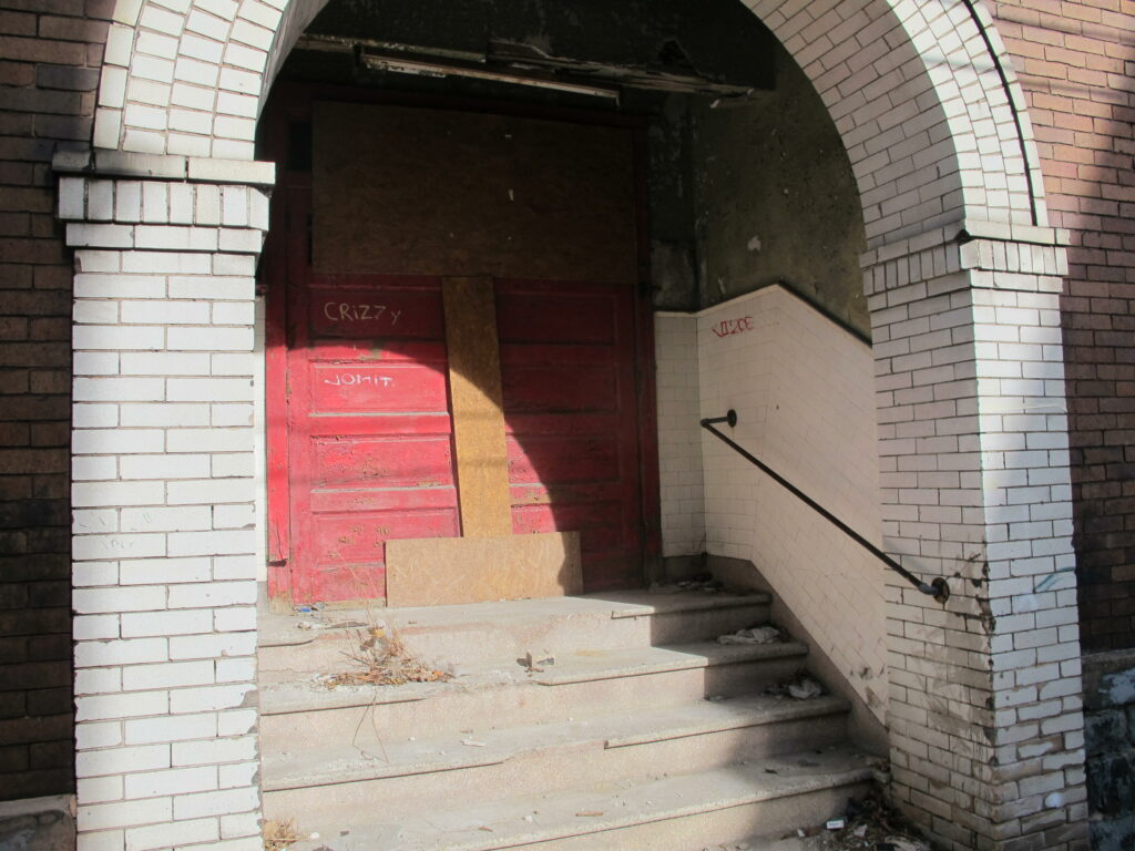 Steps leading up to a door with graffiti writing