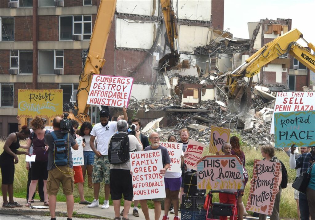 Protesters and former residents protest in front of the demolition site of the Penn Plaza in the East Liberty section of Pittsburgh